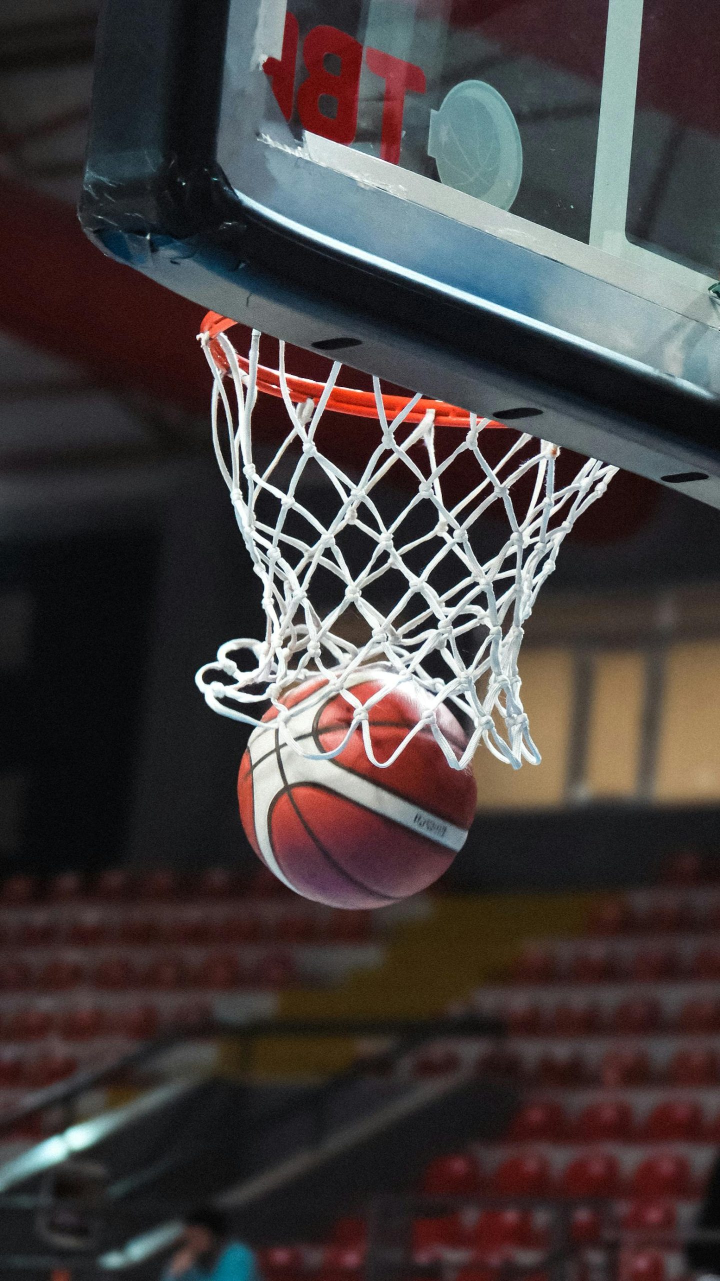 A basketball falling through a basketball hoop.